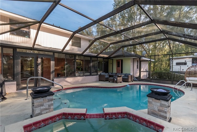 view of pool with glass enclosure, an outdoor living space, a patio, and an in ground hot tub