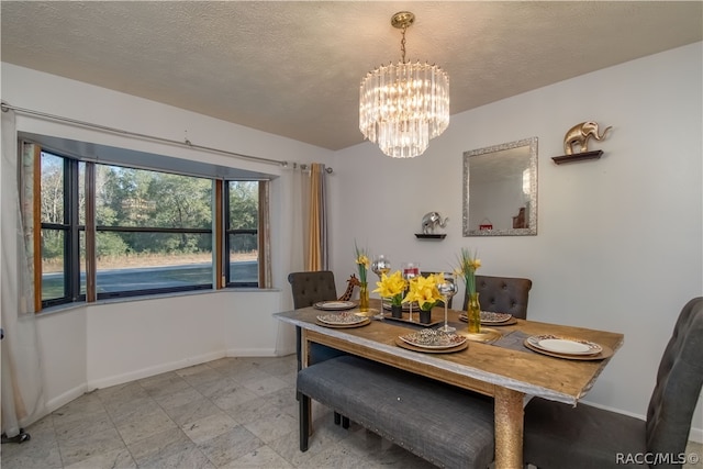 dining area with a textured ceiling and a notable chandelier