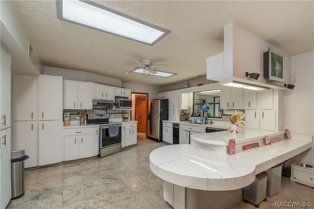 kitchen featuring white cabinets, ceiling fan, a textured ceiling, appliances with stainless steel finishes, and kitchen peninsula