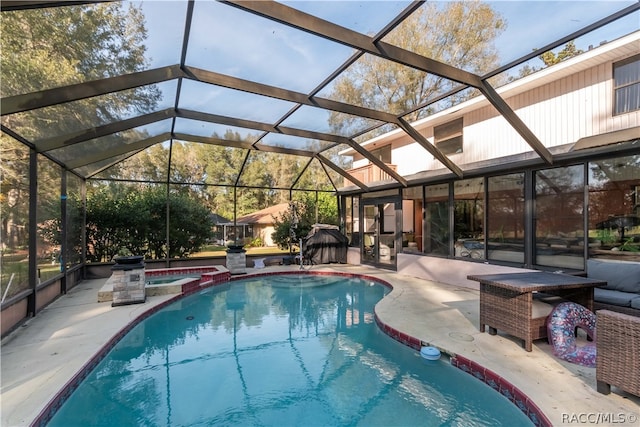 view of pool with glass enclosure, a patio area, and an in ground hot tub