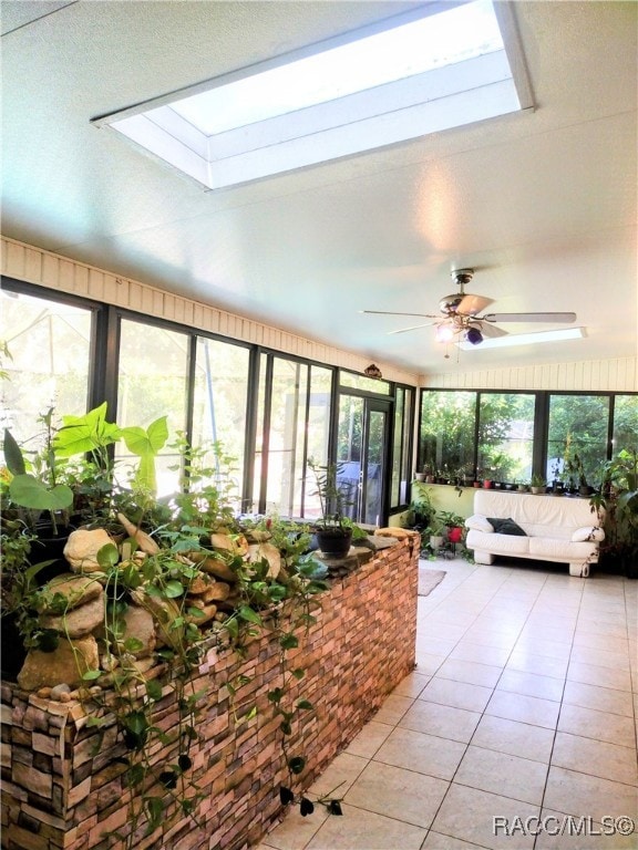 sunroom / solarium featuring ceiling fan and a skylight