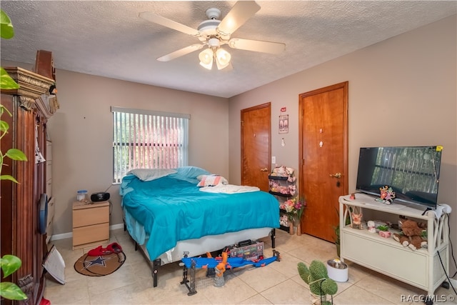 bedroom featuring light tile patterned floors, a textured ceiling, and ceiling fan