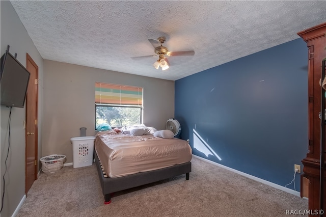 carpeted bedroom featuring a textured ceiling and ceiling fan