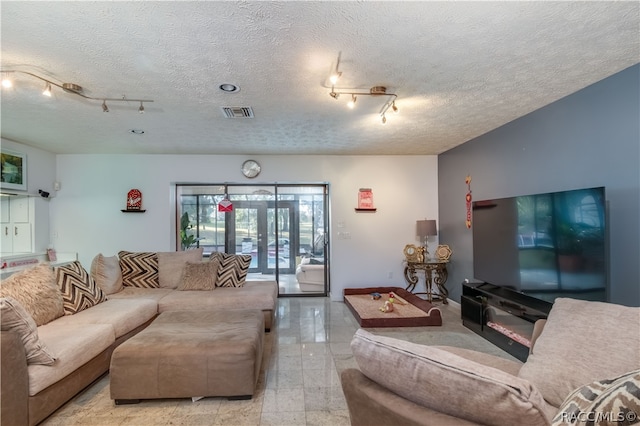 living room with track lighting, a textured ceiling, and french doors