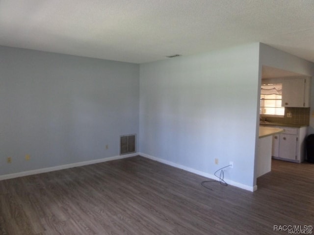 unfurnished room with dark wood-type flooring