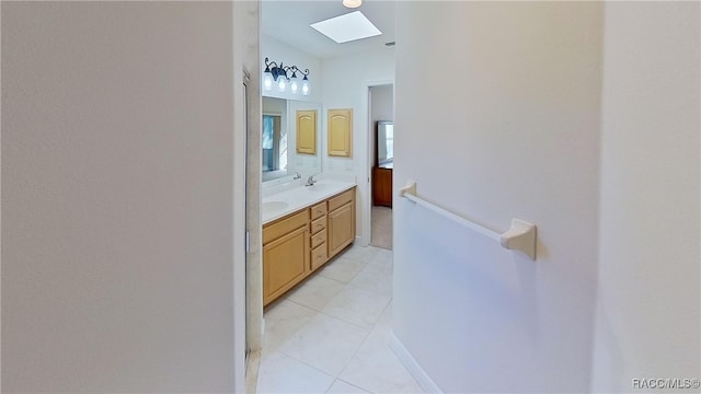 bathroom featuring tile patterned floors, vanity, and a skylight