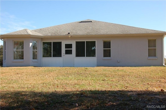 rear view of property featuring a lawn