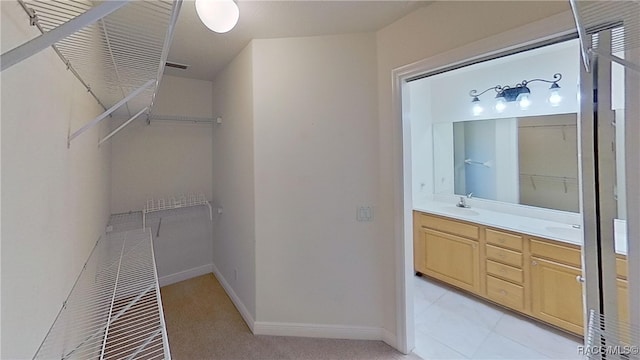 walk in closet with sink and light tile patterned flooring