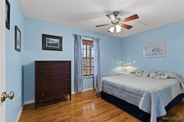 bedroom with baseboards, wood finished floors, and a ceiling fan