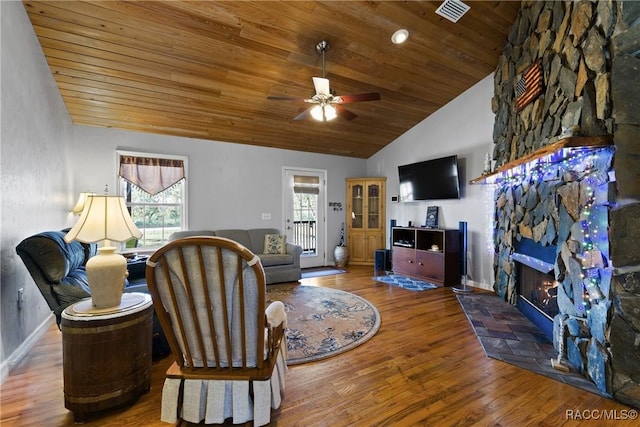 living area with visible vents, wooden ceiling, a fireplace, wood finished floors, and a ceiling fan