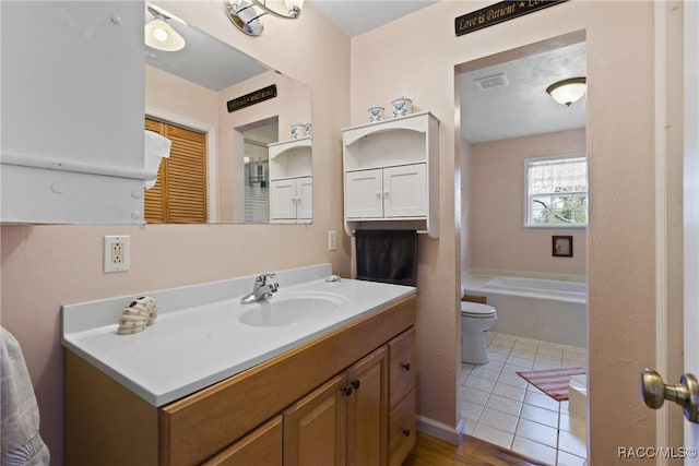 bathroom with tile patterned flooring, visible vents, toilet, a bathing tub, and vanity