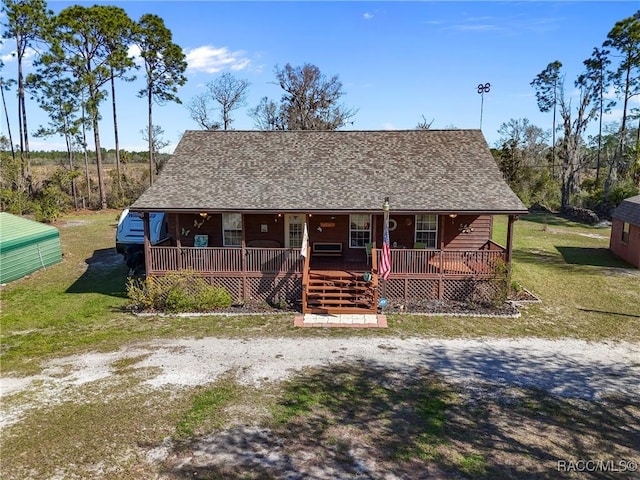 view of front of home with a porch, a front yard, and roof with shingles