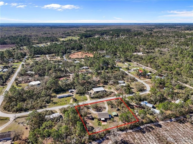 birds eye view of property featuring a wooded view