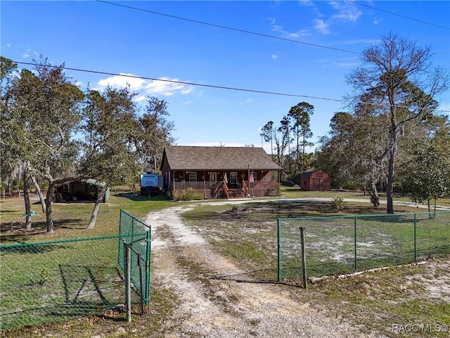 view of front of house with an outbuilding, covered porch, fence, and dirt driveway