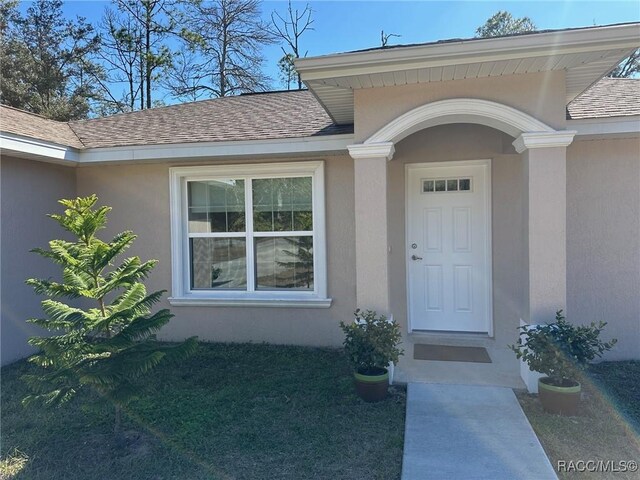 entrance to property featuring a yard