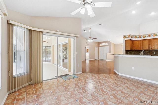 interior space with ceiling fan, lofted ceiling, sink, and a wealth of natural light