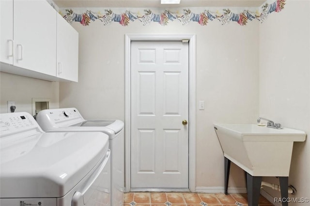 washroom featuring light tile patterned floors, sink, washing machine and dryer, and cabinets