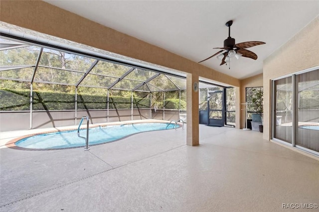 view of swimming pool with ceiling fan, a lanai, and a patio area