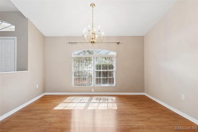 unfurnished dining area featuring lofted ceiling, hardwood / wood-style flooring, and a chandelier