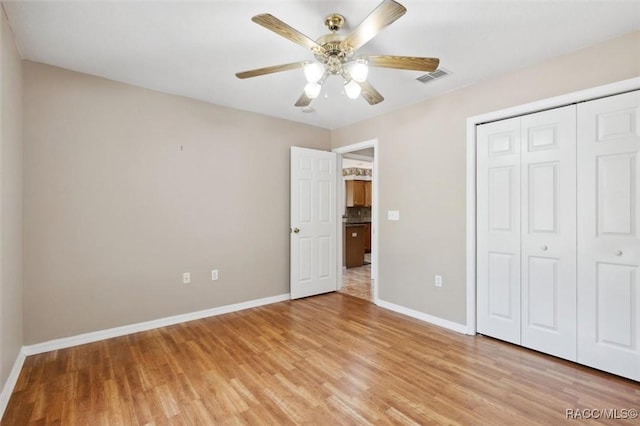 unfurnished bedroom with a closet, ceiling fan, and light wood-type flooring