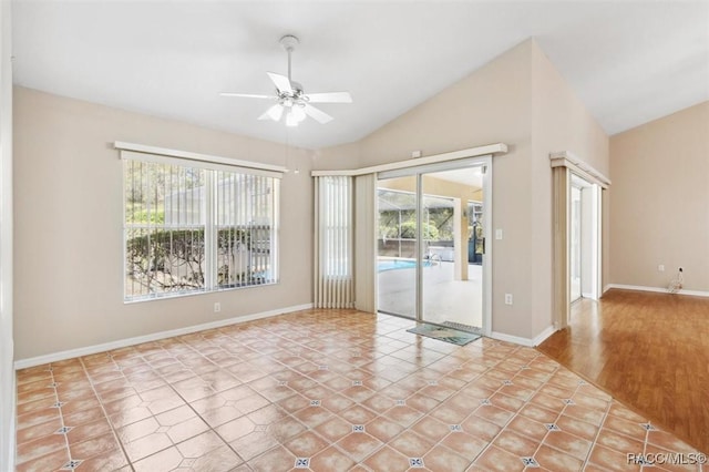 tiled empty room featuring ceiling fan, a healthy amount of sunlight, and vaulted ceiling