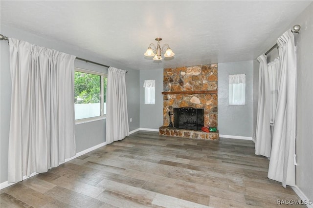 7 Michigan St, Beverly Hills, FL 34465 - unfurnished living room featuring a chandelier, wood finished floors, and a stone fireplace