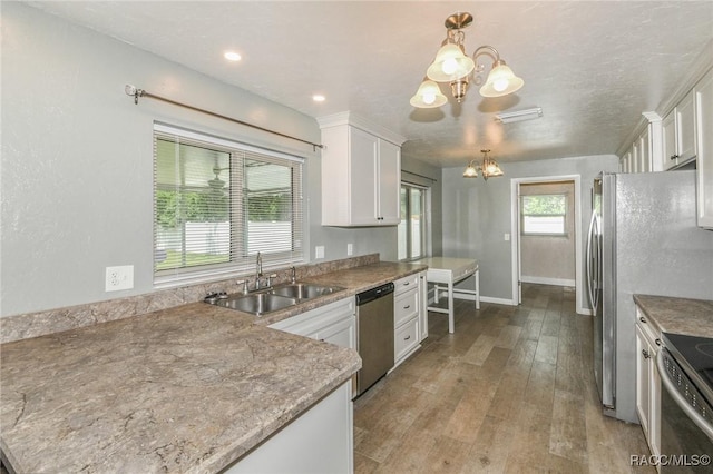 7 Michigan St, Beverly Hills, FL 34465 - kitchen with a chandelier, stainless steel appliances, white cabinetry, and hardwood / wood-style floors