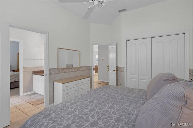 bedroom with light tile patterned flooring, a high ceiling, visible vents, a ceiling fan, and a closet