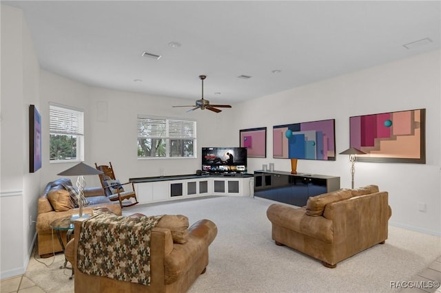 living area featuring baseboards, visible vents, and a ceiling fan