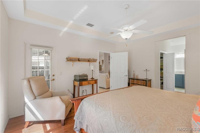 848 W Silver Meadow Loop, Hernando, FL 34442 - bedroom with light wood-type flooring, a raised ceiling, and ensuite bath