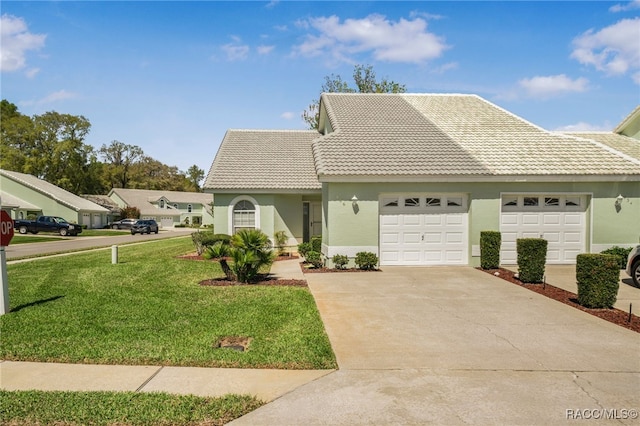 view of front of house with a tiled roof, an attached garage, driveway, and a front lawn