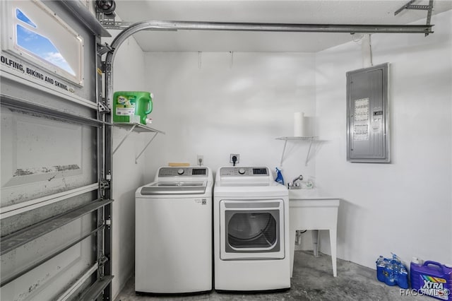 laundry area with laundry area, electric panel, a garage, and washer and clothes dryer