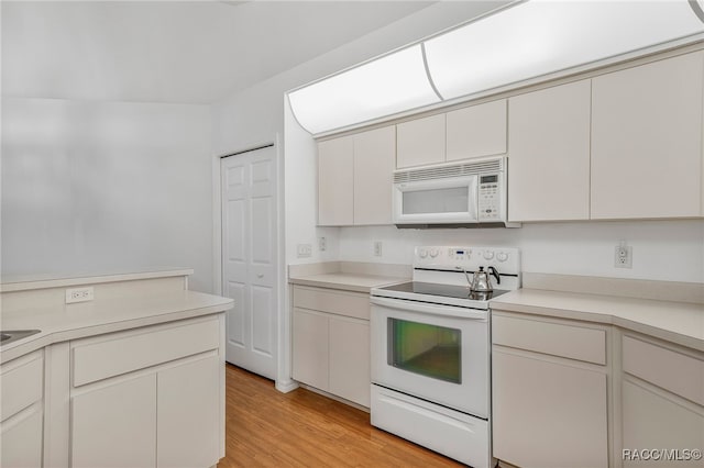 kitchen with white appliances, light wood-style flooring, and light countertops