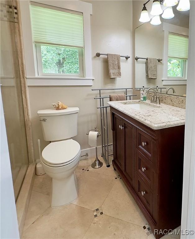 bathroom featuring vanity, tile patterned floors, a chandelier, and toilet