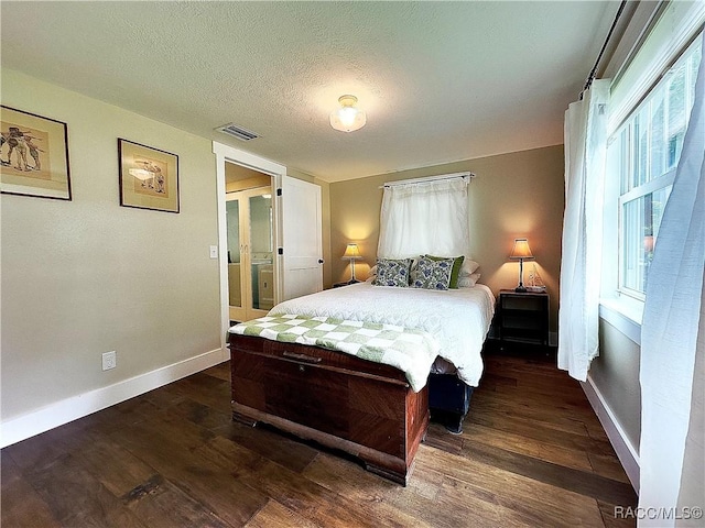 bedroom with dark wood-type flooring and a textured ceiling