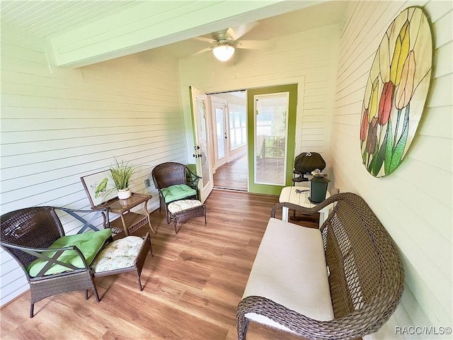 sunroom featuring ceiling fan and beamed ceiling