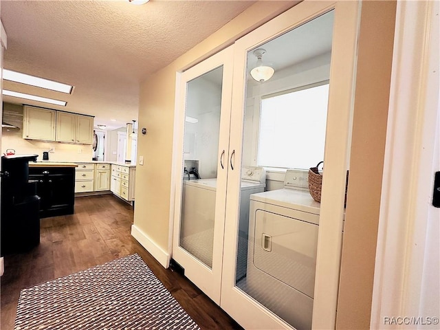 washroom featuring independent washer and dryer, dark hardwood / wood-style floors, and a textured ceiling