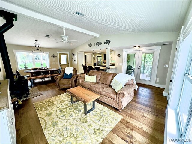 living room with hardwood / wood-style floors, plenty of natural light, lofted ceiling with beams, and french doors