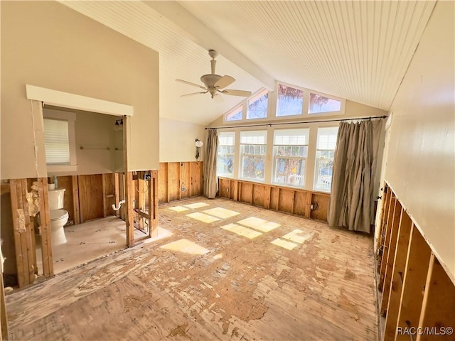 interior space featuring ceiling fan, wooden walls, high vaulted ceiling, and beamed ceiling