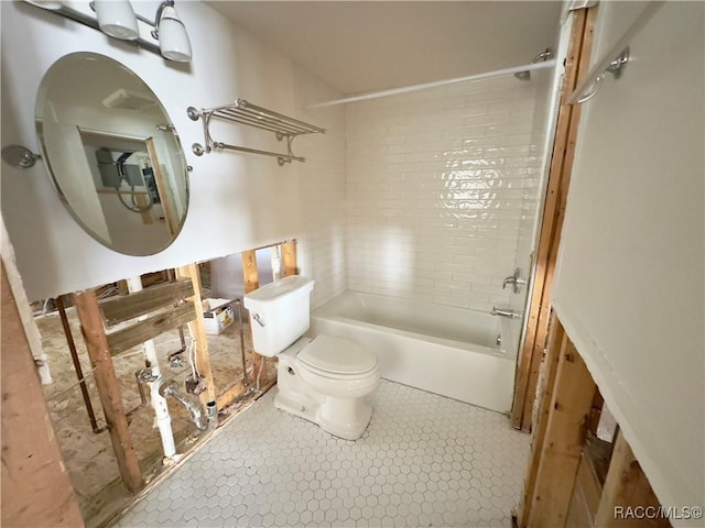 bathroom featuring tile patterned flooring, toilet, and tiled shower / bath