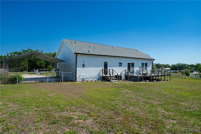 rear view of house with fence, a carport, a yard, and crawl space