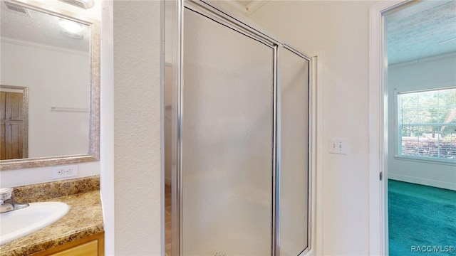 bathroom featuring vanity, a textured ceiling, a shower stall, and crown molding
