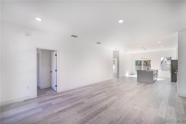 572 W Bluster Pl, Citrus Springs, FL 34434 - unfurnished living room with light wood-type flooring, recessed lighting, and a chandelier