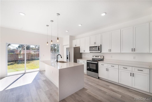 572 W Bluster Pl, Citrus Springs, FL 34434 - kitchen featuring stainless steel appliances, light wood-type flooring, white cabinets, healthy amount of natural light, and recessed lighting