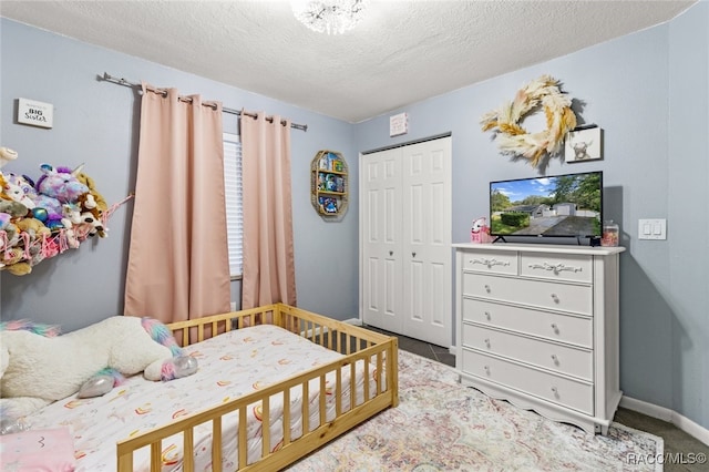 carpeted bedroom featuring a textured ceiling and a closet