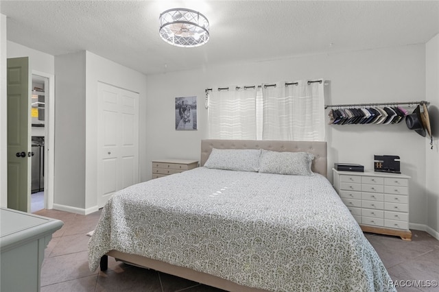 tiled bedroom with a closet and a textured ceiling