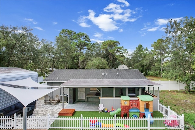 back of house with a playground and a patio area