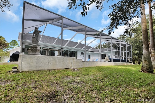 rear view of house featuring a lawn and glass enclosure