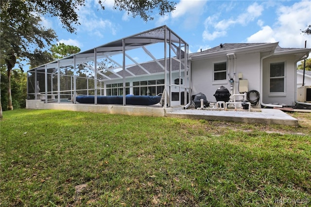 back of property featuring a lawn, glass enclosure, and a patio area