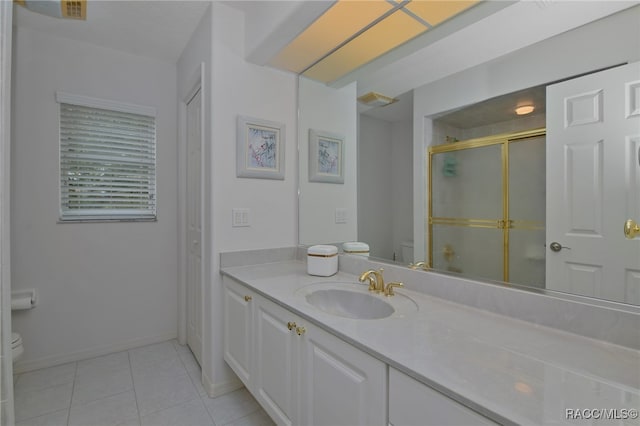 bathroom with tile patterned floors, vanity, toilet, and an enclosed shower